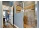 Bathroom with glass shower and neutral tile, with bedroom in the background at 6648 Castle Green Pl, Zephyrhills, FL 33541