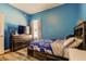 Bedroom with blue walls, wood floors and a modern wooden dresser at 6648 Castle Green Pl, Zephyrhills, FL 33541