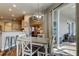 Bright dining area with sliding glass doors, modern lighting fixture, and open view of kitchen at 6648 Castle Green Pl, Zephyrhills, FL 33541