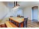 Well-lit dining area with a wooden table, chairs, bench, and modern lighting above at 6648 Castle Green Pl, Zephyrhills, FL 33541