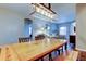 Bright dining room featuring a wooden table, bench, and an elegant light fixture overlooking the living area at 6648 Castle Green Pl, Zephyrhills, FL 33541