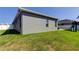 Side view of the home exterior with a green lawn and partial view of a playset at 6648 Castle Green Pl, Zephyrhills, FL 33541