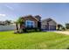 Well-maintained single Gathering home with lush green lawn, stone details, and a convenient two-car garage at 6648 Castle Green Pl, Zephyrhills, FL 33541
