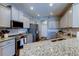 Well-lit kitchen with stainless steel appliances, granite counters, and ample cabinet space at 6648 Castle Green Pl, Zephyrhills, FL 33541