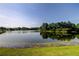 Scenic view of a tranquil lake surrounded by lush greenery under a clear sky at 6648 Castle Green Pl, Zephyrhills, FL 33541