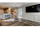 Living room that has a large television, built-in cabinets, and is open to the kitchen and dining areas at 6648 Castle Green Pl, Zephyrhills, FL 33541