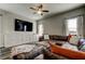 Living room with large sectional sofa, entertainment center, and ample natural light from windows at 6648 Castle Green Pl, Zephyrhills, FL 33541