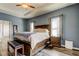 Beautiful main bedroom features a large bed, wood floors, and ample natural light from the windows at 6648 Castle Green Pl, Zephyrhills, FL 33541