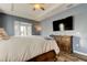 This main bedroom features a ceiling fan, an ensuite bathroom, and lovely blue walls at 6648 Castle Green Pl, Zephyrhills, FL 33541