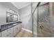 Bathroom featuring a glass shower, gray vanity with a dark countertop and decorative mirror at 718 Pinckney Dr, Apollo Beach, FL 33572
