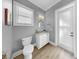 Powder room with gray walls, toilet, white vanity with a granite countertop and mirror at 718 Pinckney Dr, Apollo Beach, FL 33572