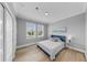 This bedroom features two bright windows, a queen bed and coastal decor at 718 Pinckney Dr, Apollo Beach, FL 33572