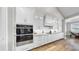 Close-up of kitchen with modern appliances, custom cabinetry, and sleek countertops with mosaic backsplash at 718 Pinckney Dr, Apollo Beach, FL 33572