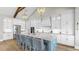 Spacious kitchen featuring a blue island with seating, white cabinets, stainless appliances, and decorative lighting at 718 Pinckney Dr, Apollo Beach, FL 33572