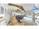 Spacious living area with exposed beams, fireplace, oversized sectional sofa, and access to the outdoor space at 718 Pinckney Dr, Apollo Beach, FL 33572