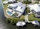 Aerial view of home with boat dock and lift, beautiful pool area, and meticulously kept landscaping at 718 Pinckney Dr, Apollo Beach, FL 33572