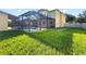 Expansive backyard features a screened pool area, lush lawn, and mature trees, providing privacy and space at 7711 Nottinghill Sky Dr, Apollo Beach, FL 33572