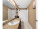 Well-lit bathroom with granite vanity, white tiled shower-tub, and neutral-toned walls at 7711 Nottinghill Sky Dr, Apollo Beach, FL 33572