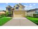 Charming two-story home with a manicured lawn and a two-car garage, under a sunny blue sky at 7711 Nottinghill Sky Dr, Apollo Beach, FL 33572