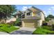 Charming two-story home with a manicured lawn and a two-car garage, surrounded by lush trees at 7711 Nottinghill Sky Dr, Apollo Beach, FL 33572