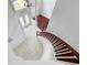Aerial view of the front foyer featuring white tile, curved staircase, and hardwood floors at 7711 Nottinghill Sky Dr, Apollo Beach, FL 33572