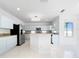 Spacious kitchen with a large island, granite countertops, stainless steel appliances, and a stylish chandelier at 7711 Nottinghill Sky Dr, Apollo Beach, FL 33572