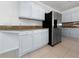 Kitchen features stainless steel appliances, granite countertops, and ample cabinet space for storage and organization at 7711 Nottinghill Sky Dr, Apollo Beach, FL 33572