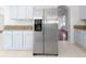 Open kitchen boasts a stainless steel fridge, granite countertops, and recessed lighting for modern appeal at 7711 Nottinghill Sky Dr, Apollo Beach, FL 33572