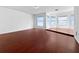 Expansive living room featuring hardwood floors and large windows with scenic views at 7711 Nottinghill Sky Dr, Apollo Beach, FL 33572