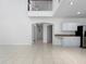 Spacious living area with tile flooring that opens up to the kitchen and features an arched entry and second-floor balcony at 7711 Nottinghill Sky Dr, Apollo Beach, FL 33572