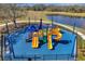 A colorful playground with multiple slides and climbing structures overlooking a pond and green space at 7711 Nottinghill Sky Dr, Apollo Beach, FL 33572