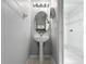 Well-lit powder room featuring a pedestal sink and oval mirror at 7711 Nottinghill Sky Dr, Apollo Beach, FL 33572