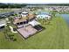 Aerial view of the community pool and playground with lakeside views in a well-maintained neighborhood at 7774 Sail Clover Ln, Zephyrhills, FL 33540