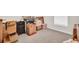An unused spare room featuring neutral gray carpet and packed cardboard boxes for moving and storage at 7774 Sail Clover Ln, Zephyrhills, FL 33540