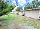 Backyard view showing a home with a stucco style exterior and lush green lawn at 7908 Croton Ave, Tampa, FL 33619