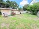 Backyard view showing a home with a stucco style exterior and lush green lawn at 7908 Croton Ave, Tampa, FL 33619