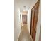 Long hallway with neutral colors and wooden doors, leading to various rooms in the home at 7908 Croton Ave, Tampa, FL 33619