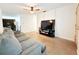 Living room featuring a sofa, TV, ceiling fan, and access to other rooms at 7908 Croton Ave, Tampa, FL 33619