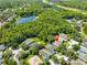 Beautiful aerial view of home in lush surroundings with a lake and nearby community at 8213 Swann Hollow Dr, Tampa, FL 33647