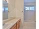 Bright bathroom featuring a single sink vanity and a shower-over-tub combination, natural light from a window at 8213 Swann Hollow Dr, Tampa, FL 33647