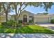 Charming single-story home with a manicured lawn, mature trees, and a two-car garage at 8213 Swann Hollow Dr, Tampa, FL 33647