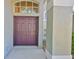 Elegant double front door with upper transom window and textured siding at 8213 Swann Hollow Dr, Tampa, FL 33647