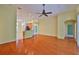 Open living room with wood floors, a ceiling fan, and bar-height seating to the kitchen at 8213 Swann Hollow Dr, Tampa, FL 33647
