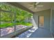 Covered patio leading to a fenced backyard with a green lawn at 8213 Swann Hollow Dr, Tampa, FL 33647
