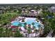 Community aerial view of a large pool with lounge chairs, palm trees, and shaded cabanas near houses at 8515 Hunters Fork Loop, Ruskin, FL 33573