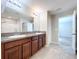 Bathroom showcasing a double vanity with dark cabinets, tile floors, and a door to the water closet at 8515 Hunters Fork Loop, Ruskin, FL 33573