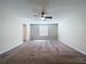 Bright, carpeted bedroom features a window, ceiling fan, and neutral paint, ready for personalization at 8515 Hunters Fork Loop, Ruskin, FL 33573