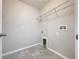 Functional laundry room with tiled floors and metal shelving for storage space at 8515 Hunters Fork Loop, Ruskin, FL 33573