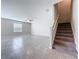 An open living room with tile flooring, stairs to the second floor, and a window at 8515 Hunters Fork Loop, Ruskin, FL 33573