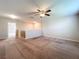Spacious carpeted loft area featuring a ceiling fan and natural light from a nearby window at 8515 Hunters Fork Loop, Ruskin, FL 33573